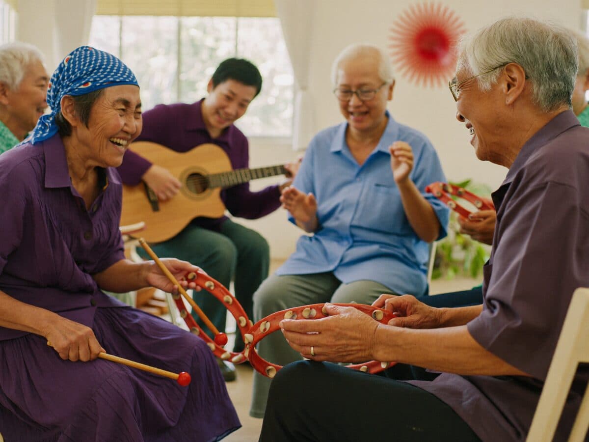 Seniors singing and playing tambourines in a group music therapy circle at MS Care